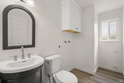 a bathroom with a sink a toilet and mirror