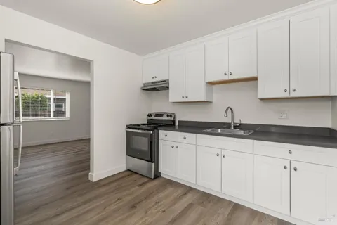 a kitchen with granite countertop white cabinets and white appliances