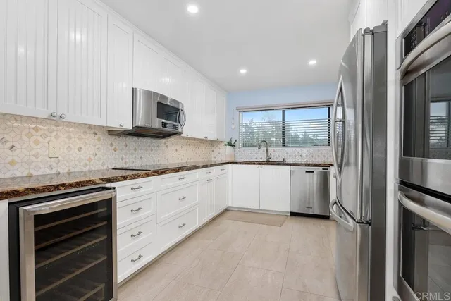 a kitchen with granite countertop white cabinets and white appliances