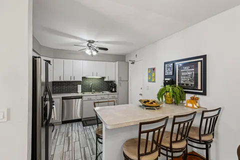 a kitchen with a table chairs and refrigerator
