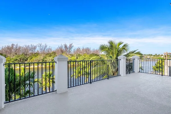 a view of a lake from a balcony with outdoor seating