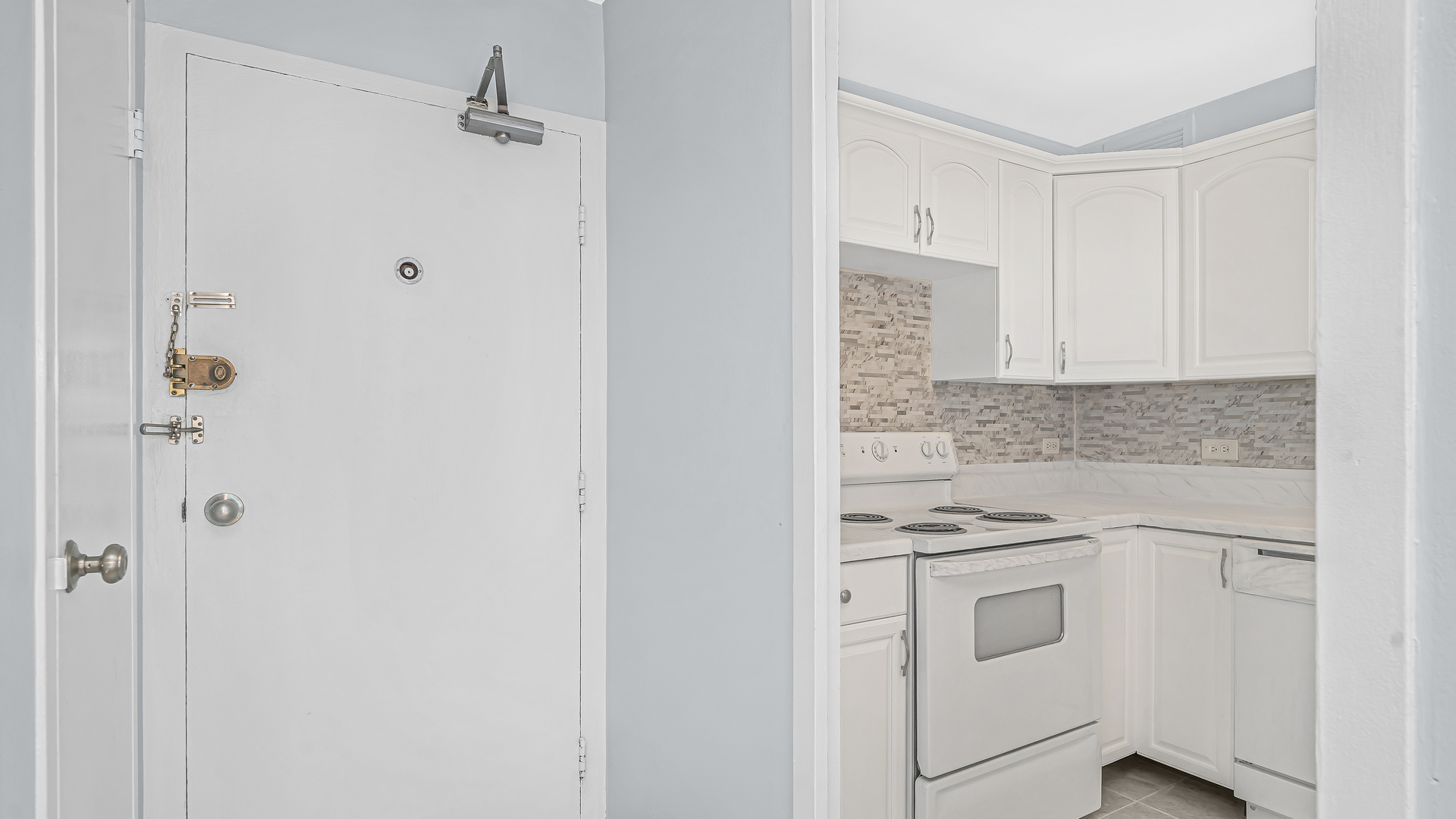 6157 North Sheridan Road, Unit 18K Chicago, IL 60660 - Photo 11 of 14 a kitchen with white cabinets and white appliances