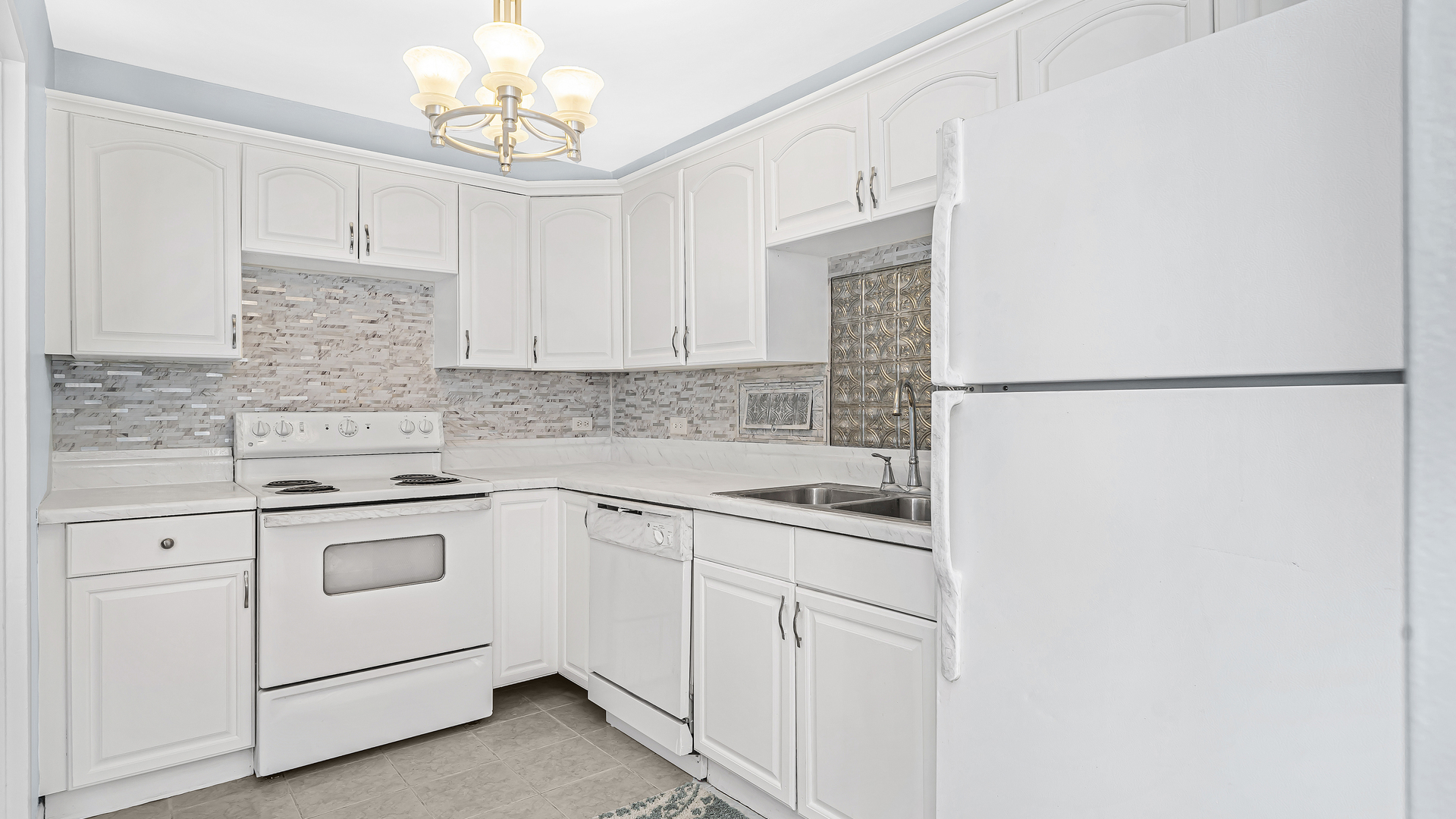 6157 North Sheridan Road, Unit 18K Chicago, IL 60660 - Photo 6 of 14 a kitchen with white cabinets and white appliances