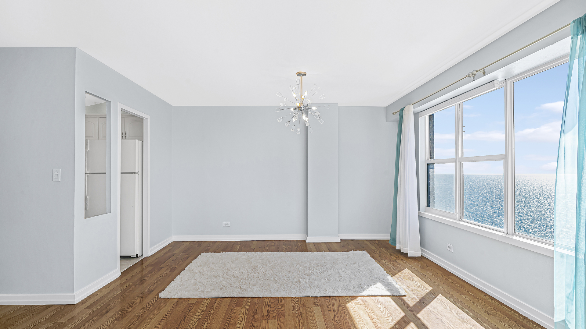 6157 North Sheridan Road, Unit 18K Chicago, IL 60660 - Photo 7 of 14 wooden floor in an empty room with a window