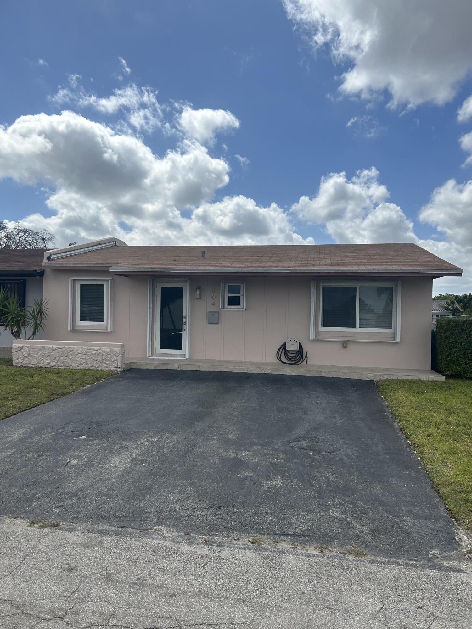 2004 Southwest 131st Place Miami, FL 33175 - Photo 1 of 16 a front view of a house with a garden