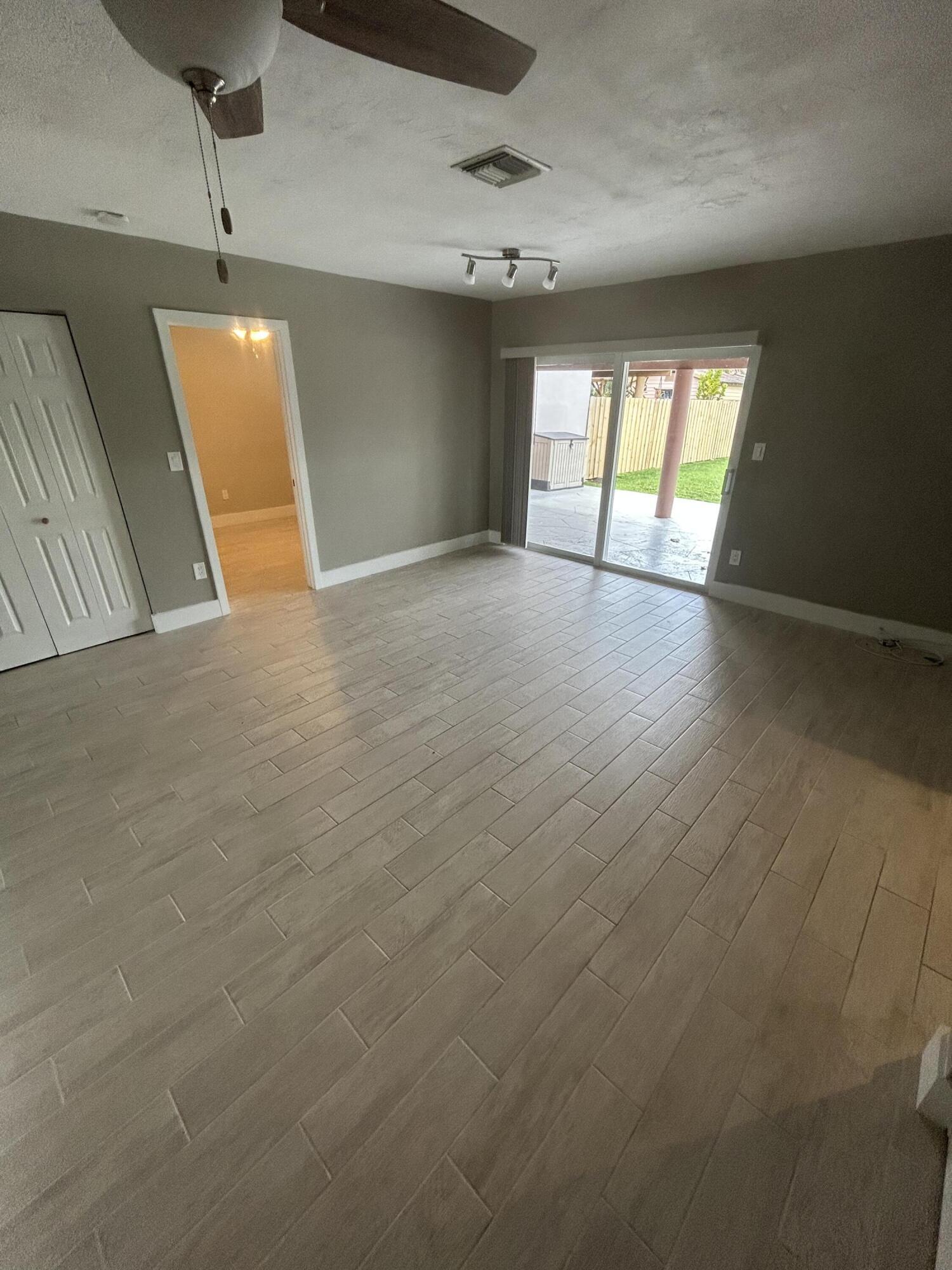 2004 Southwest 131st Place Miami, FL 33175 - Photo 10 of 16 an empty room with wooden floor and windows