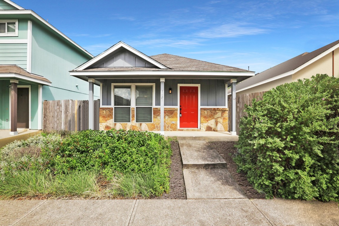 View of front of home with board and batten siding, a porch, stone siding, and a shingled roof