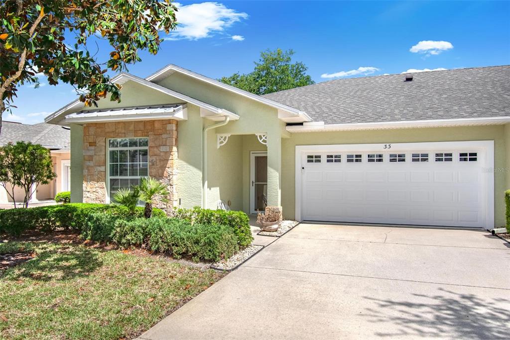 33 Summerwind Circle, Unit 101 Palm Coast, FL 32137 - Photo 1 of 45 a front view of a house with a yard and garage