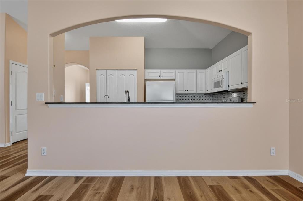 33 Summerwind Circle, Unit 101 Palm Coast, FL 32137 - Photo 26 of 45 a view of a kitchen with white cabinets and wooden floor