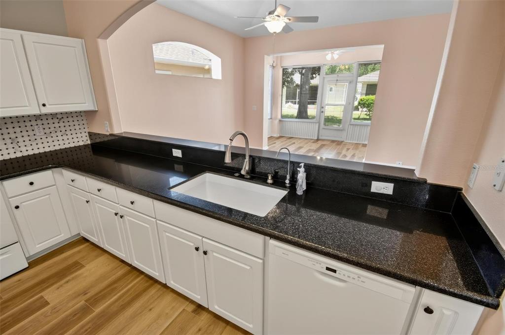 33 Summerwind Circle, Unit 101 Palm Coast, FL 32137 - Photo 31 of 45 a kitchen with granite countertop white cabinets and sink