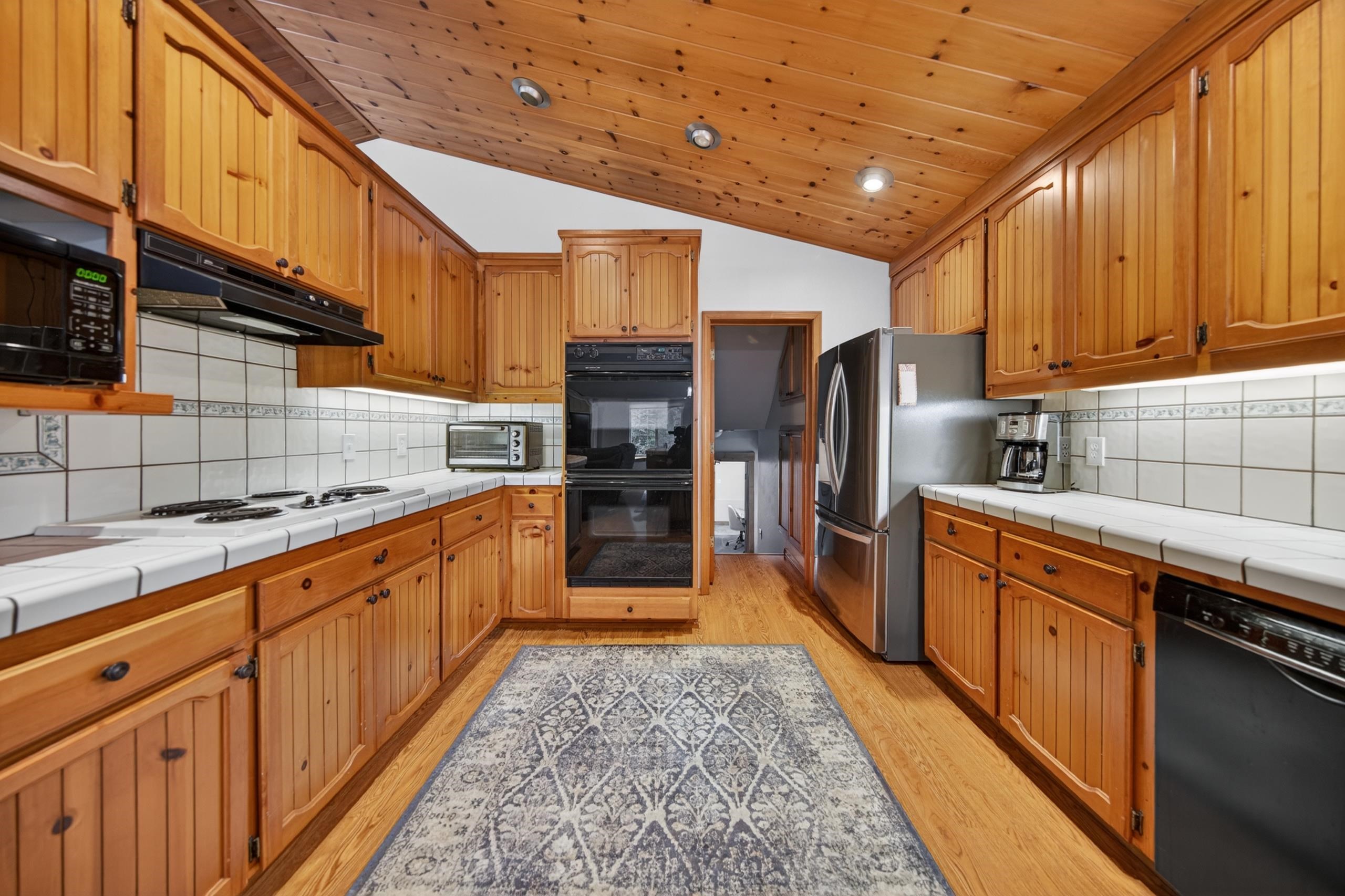 1220 Lynx Road Lake Almanor, CA 96137 - Photo 17 of 45 a large kitchen with stainless steel appliances wooden cabinets a stove and a refrigerator