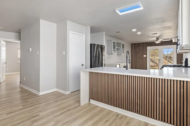 a view of a hallway with wooden floor and windows