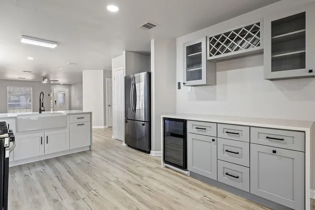 a kitchen with white cabinets and refrigerator