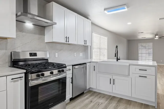 a kitchen with white cabinets and appliances