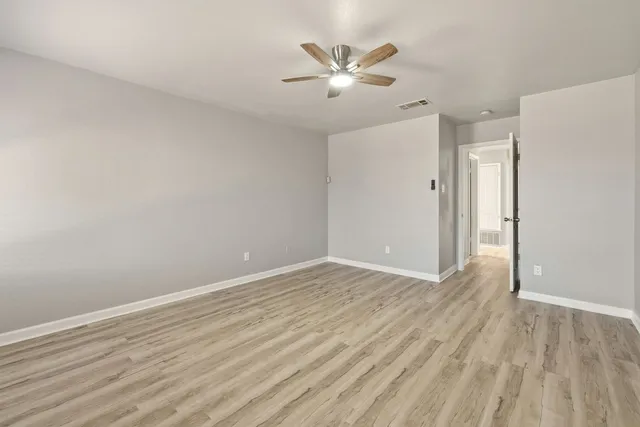 a view of an empty room with wooden floor