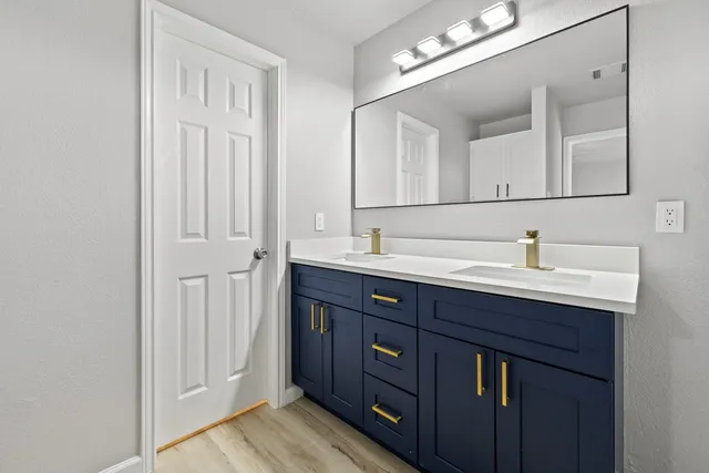 a bathroom with a double vanity sink and a mirror