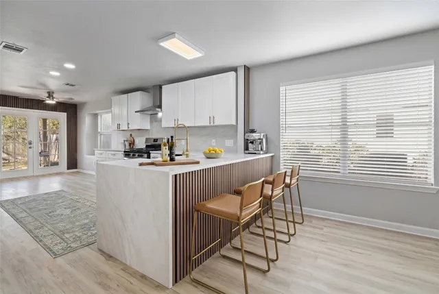 a kitchen with stainless steel appliances granite countertop a sink and a refrigerator