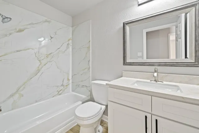 a bathroom with a sink toilet vanity and bathtub