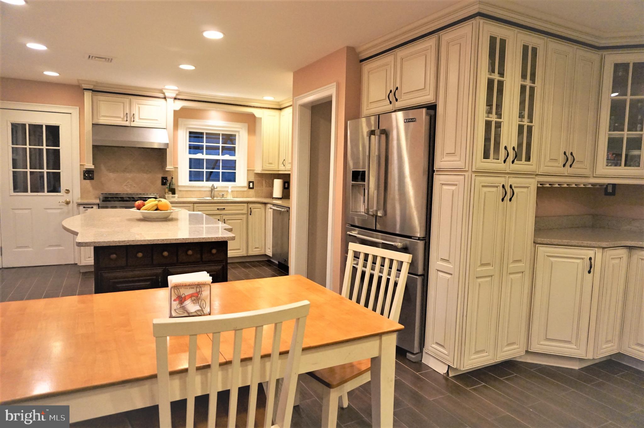 74 Marion Road East Princeton, NJ 08540 - Photo 11 of 32 a kitchen with stainless steel appliances granite countertop a refrigerator a stove and white cabinets with wooden floor