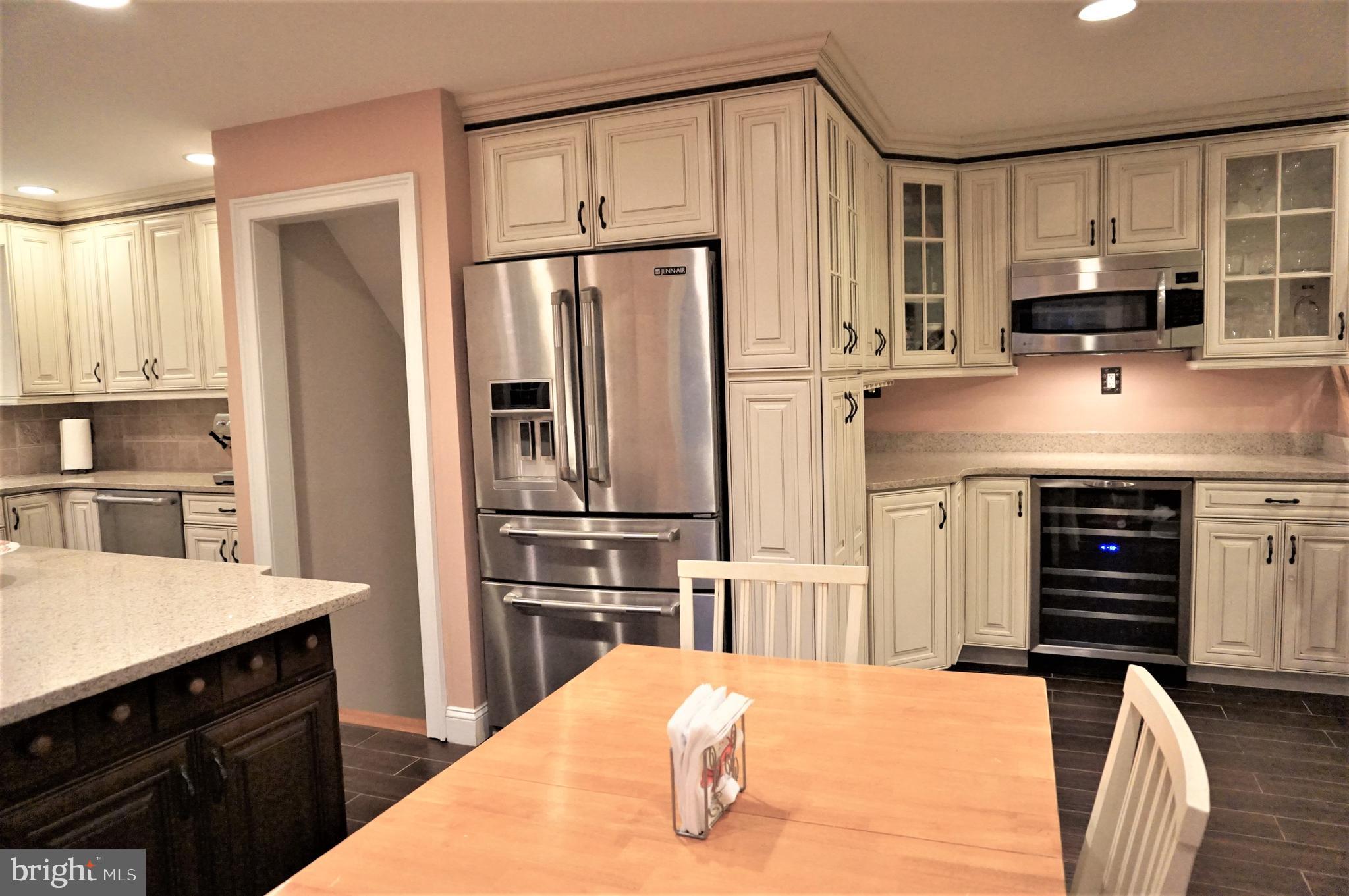 74 Marion Road East Princeton, NJ 08540 - Photo 13 of 32 a kitchen with stainless steel appliances kitchen island granite countertop a refrigerator a stove a sink and white cabinets with wooden floor
