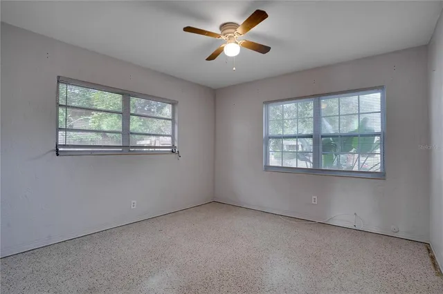 an empty room with a ceiling fan and a fan