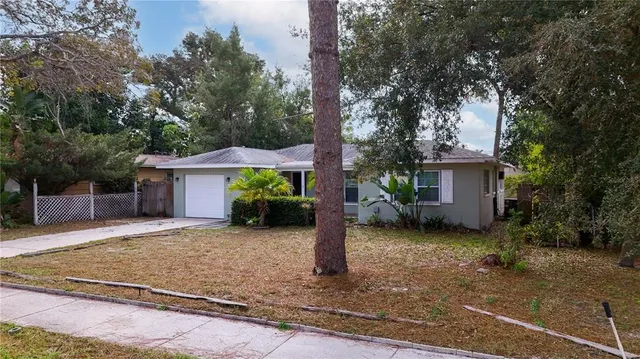 a view of a house with a yard and tree