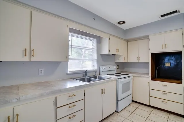 a kitchen with white cabinets and white appliances