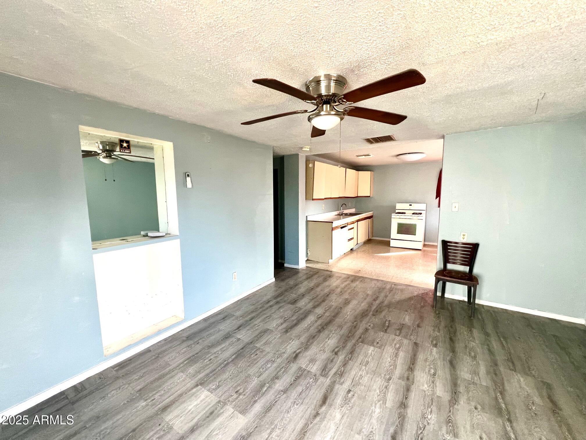 2002 West Lawrence Road Phoenix, AZ 85015 - Photo 14 of 22 a view of a livingroom with a furniture wooden floor and a ceiling fan