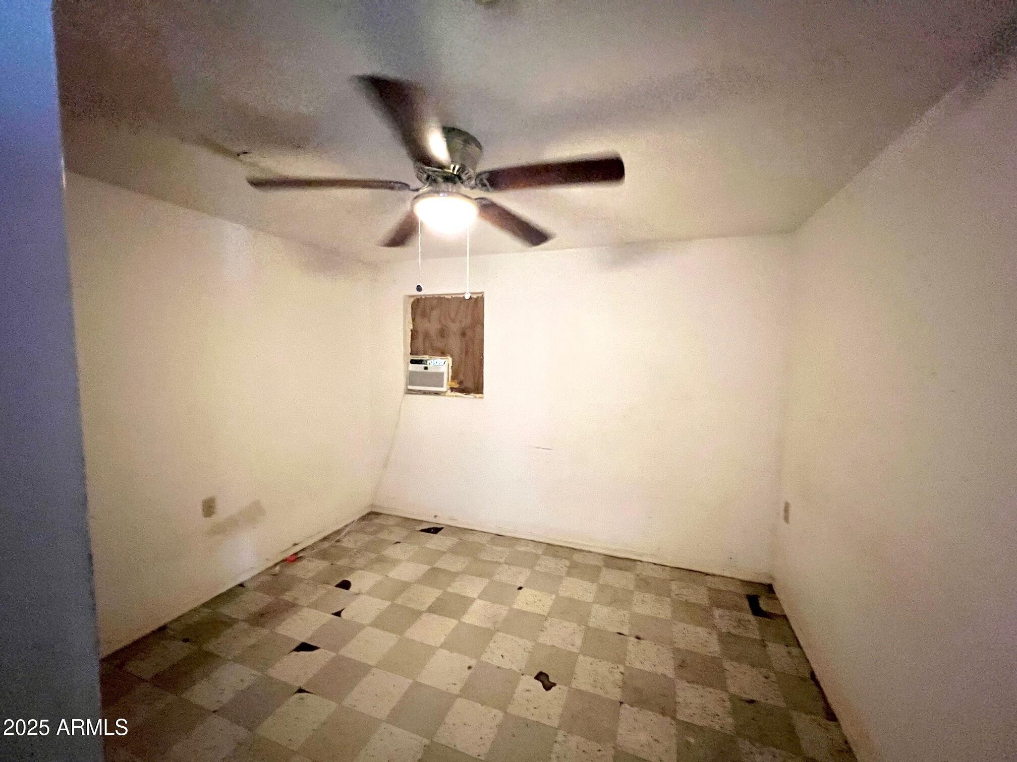 2002 West Lawrence Road Phoenix, AZ 85015 - Photo 17 of 22 an empty room with a chandelier fan and windows