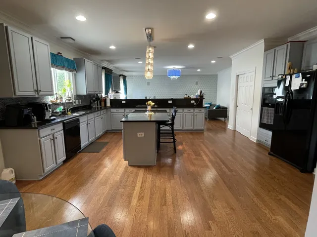 an open kitchen with kitchen island and stainless steel appliances