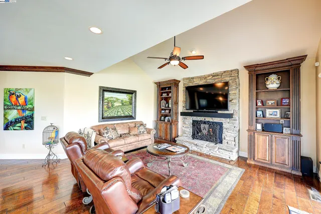 a kitchen with stainless steel appliances kitchen island granite countertop a table chairs and a wooden floor