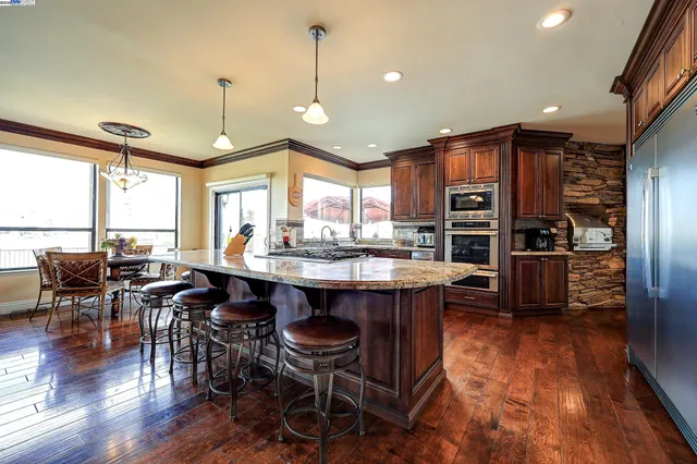 a kitchen with stainless steel appliances granite countertop a stove and wooden cabinets