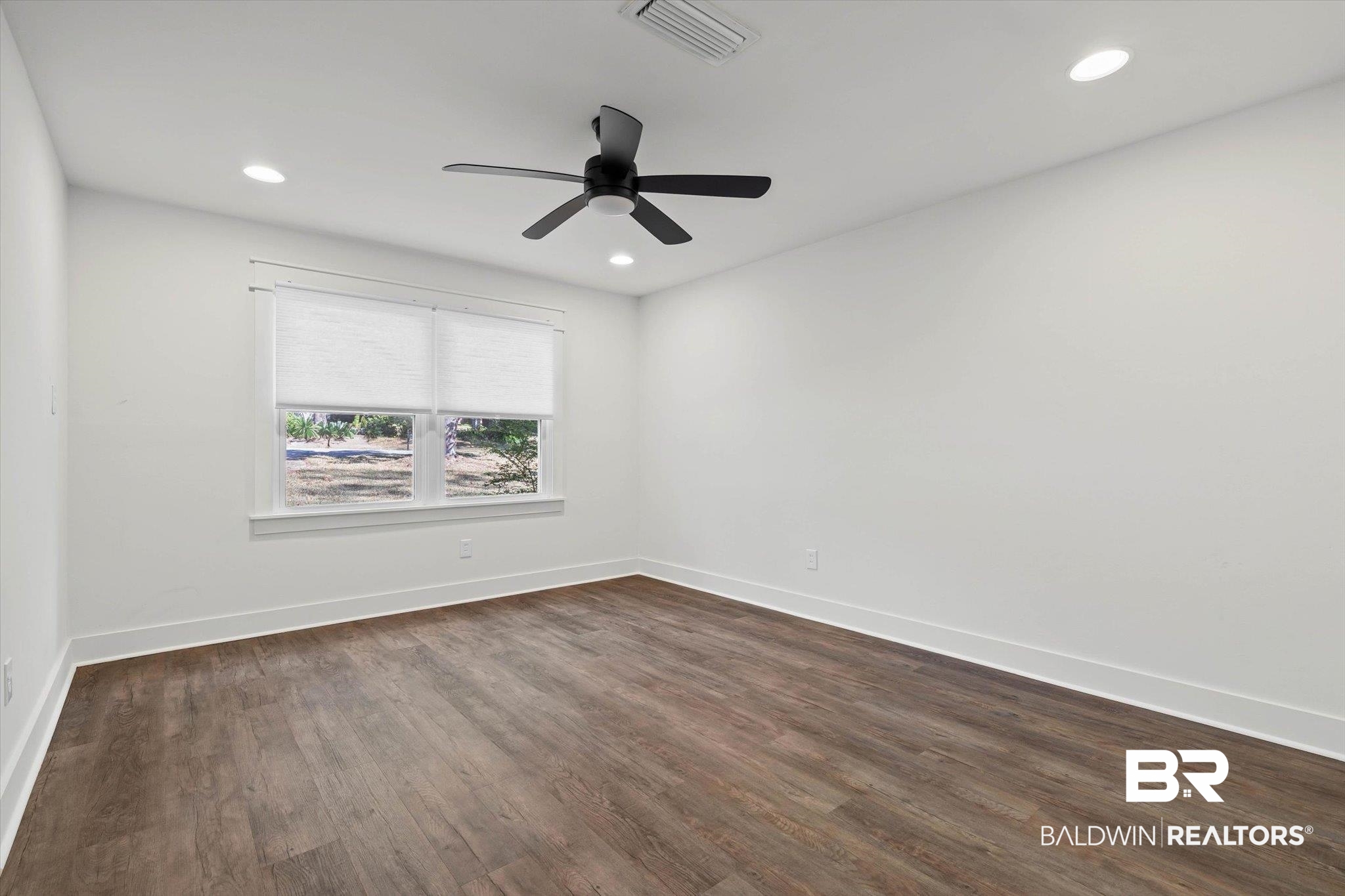 3933 Radnor Avenue Mobile, AL 36608 - Photo 15 of 36 Downstairs potential Primary Bedroom - featuring dark wood-style floors, ceiling fan, and recessed lighting. Dual Primary Bedrooms in this home - one upstairs as well! Could also be used as a BONUS Room or Media Room, Craft Room, Home Office, options ...