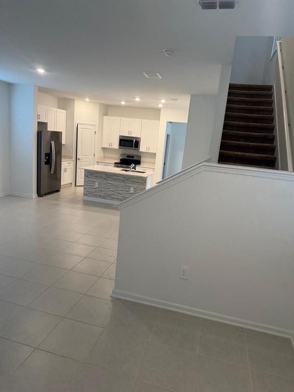 1770 Rider Rain Lane Apopka, FL 32703 - Photo 12 of 86 a kitchen with stainless steel appliances a refrigerator and a stove top oven