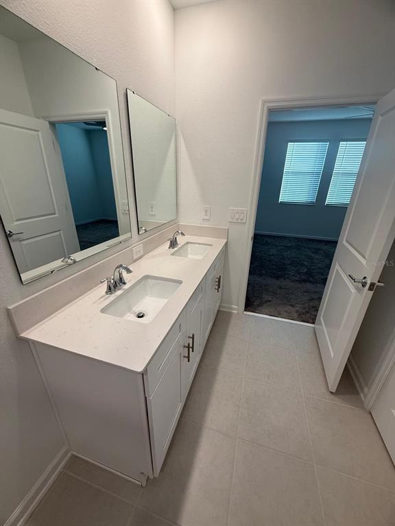 1770 Rider Rain Lane Apopka, FL 32703 - Photo 46 of 86 a bathroom with a double vanity sink and mirror