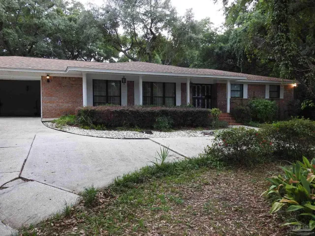 a front view of a house with a garden and plants