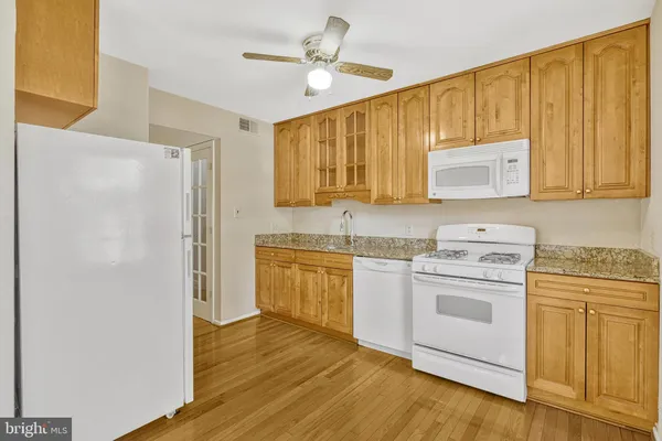 a kitchen with stainless steel appliances granite countertop a refrigerator sink and stove