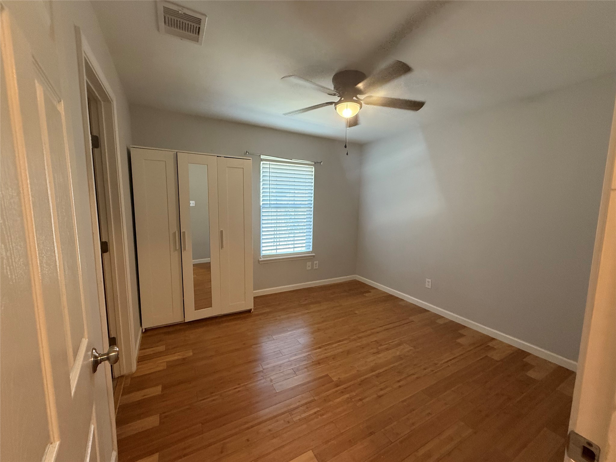 3115 Lorikeet Street Spring, TX 77373 - Photo 6 of 12 an empty room with wooden floor and windows