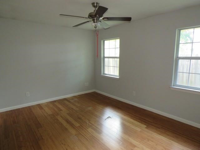 3115 Lorikeet Street Spring, TX 77373 - Photo 8 of 12 an empty room with wooden floor windows and fan