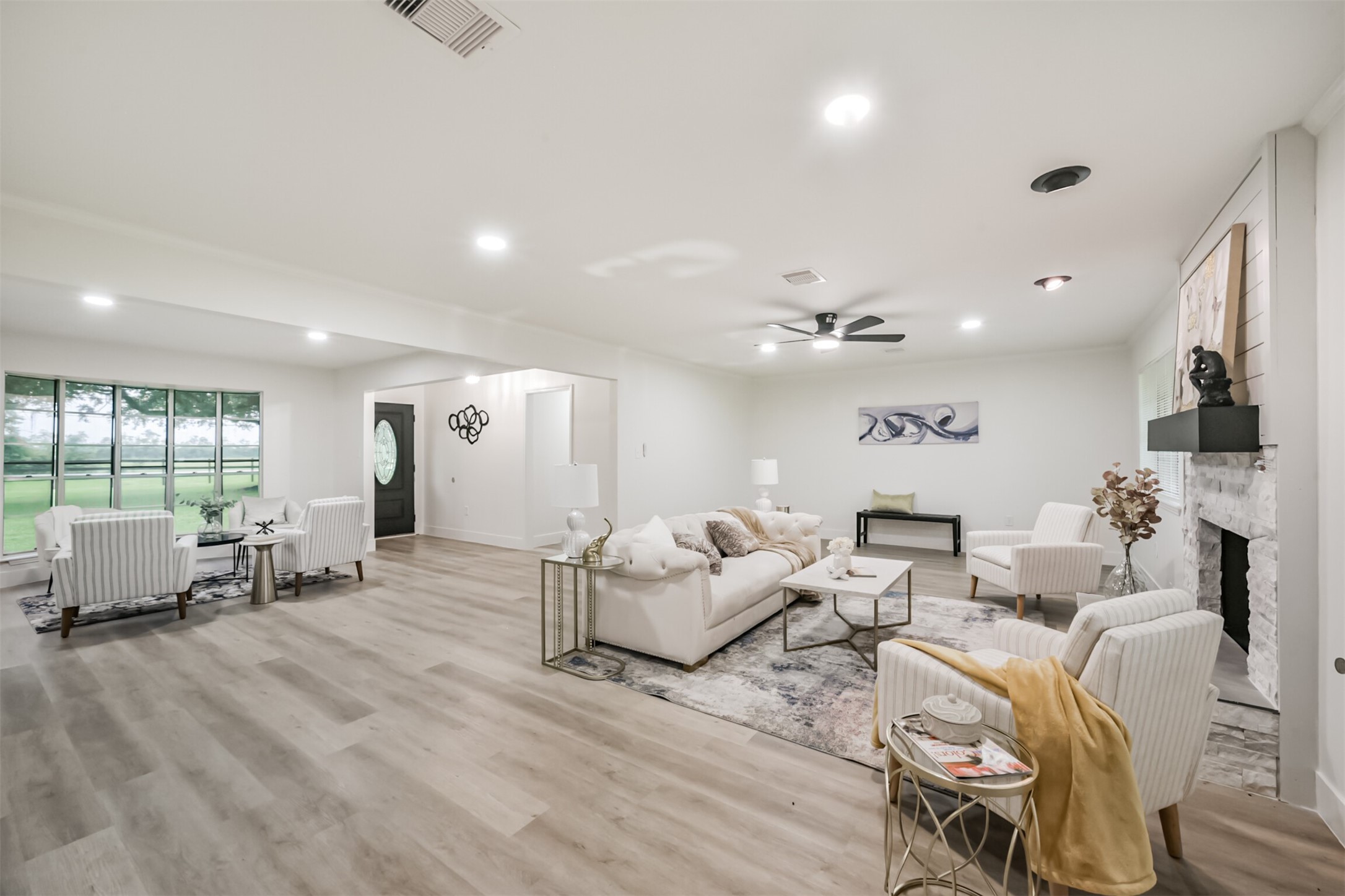5403 Croix Road Manvel, TX 77578 - Photo 13 of 25 Bright and spacious open-concept living room featuring updated flooring, recessed lighting, and a cozy fireplace that creates the perfect gathering space.