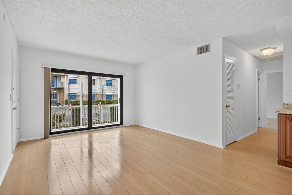 130 Cypress Club Drive, Unit 307 Pompano Beach, FL 33060 - Photo 19 of 35 a view of an empty room with wooden floor and a window