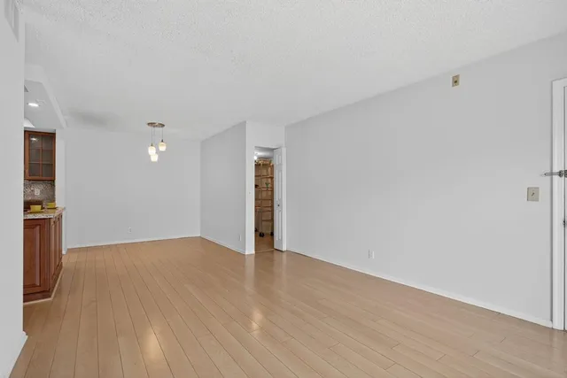 a view of an empty room with wooden floor