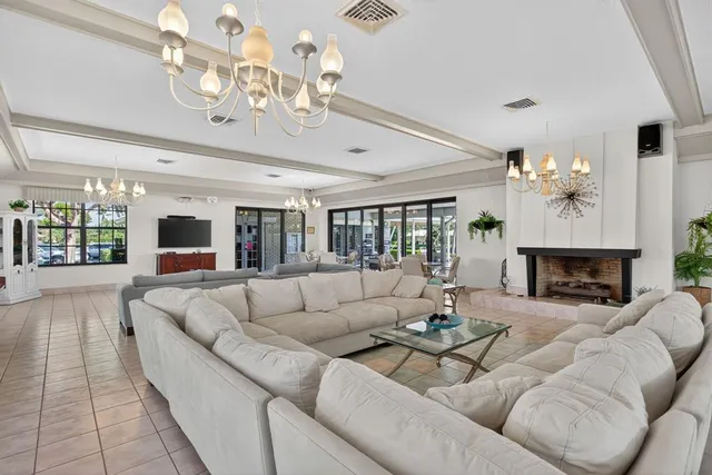 a living room with furniture a chandelier and a fireplace