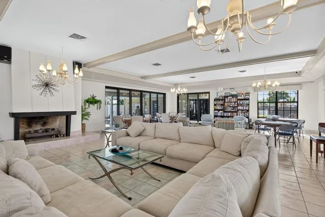 a living room with furniture a fireplace and a chandelier
