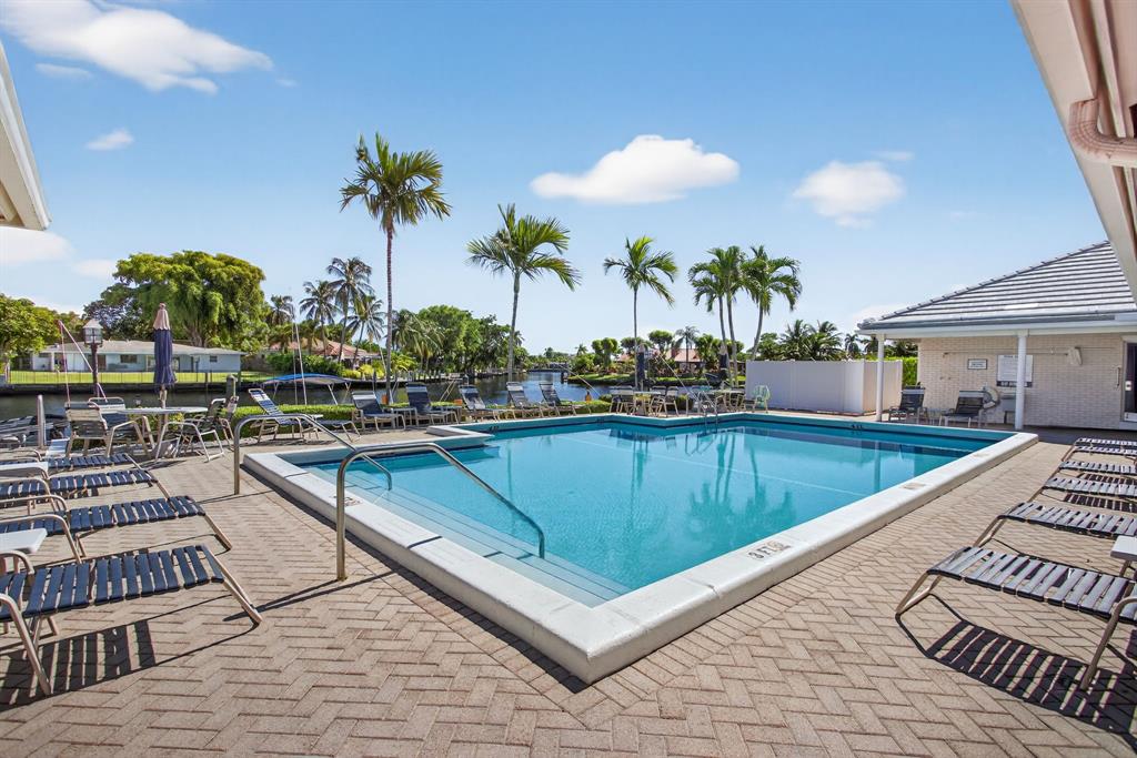 130 Cypress Club Drive, Unit 307 Pompano Beach, FL 33060 - Photo 32 of 35 a view of a swimming pool with outdoor seating
