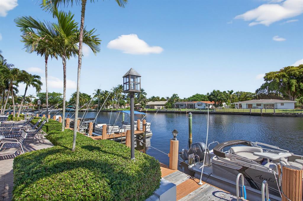 130 Cypress Club Drive, Unit 307 Pompano Beach, FL 33060 - Photo 33 of 35 a view of a lake with a table and chairs
