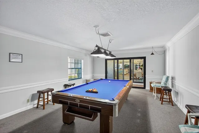 a room with pool table and windows