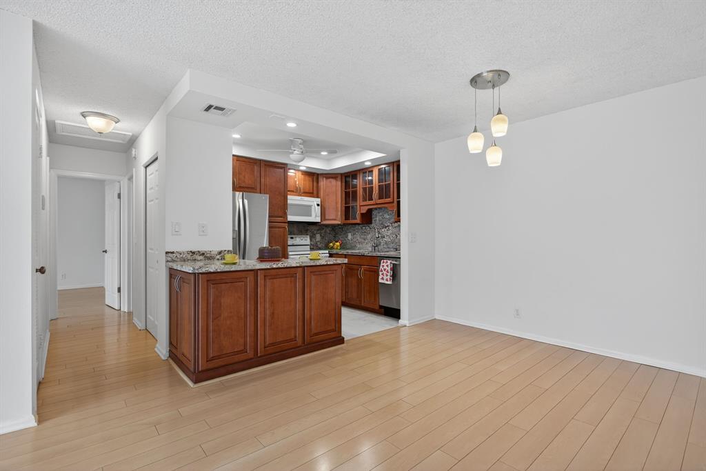 130 Cypress Club Drive, Unit 307 Pompano Beach, FL 33060 - Photo 4 of 35 a view of kitchen with wooden floor