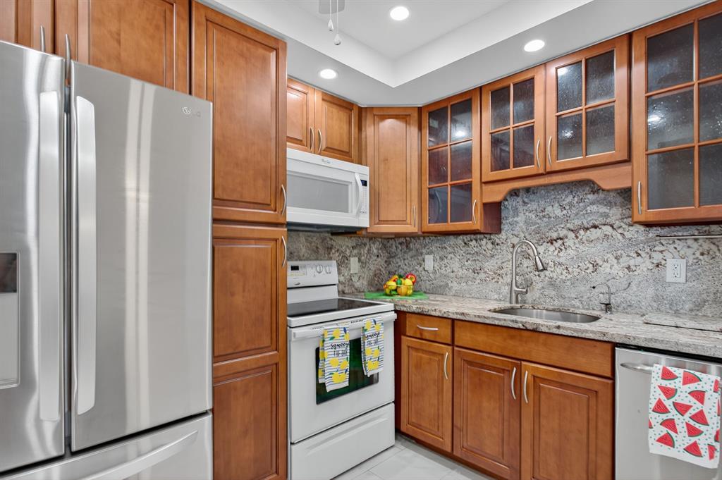 130 Cypress Club Drive, Unit 307 Pompano Beach, FL 33060 - Photo 6 of 35 a kitchen with stainless steel appliances granite countertop a refrigerator and a sink