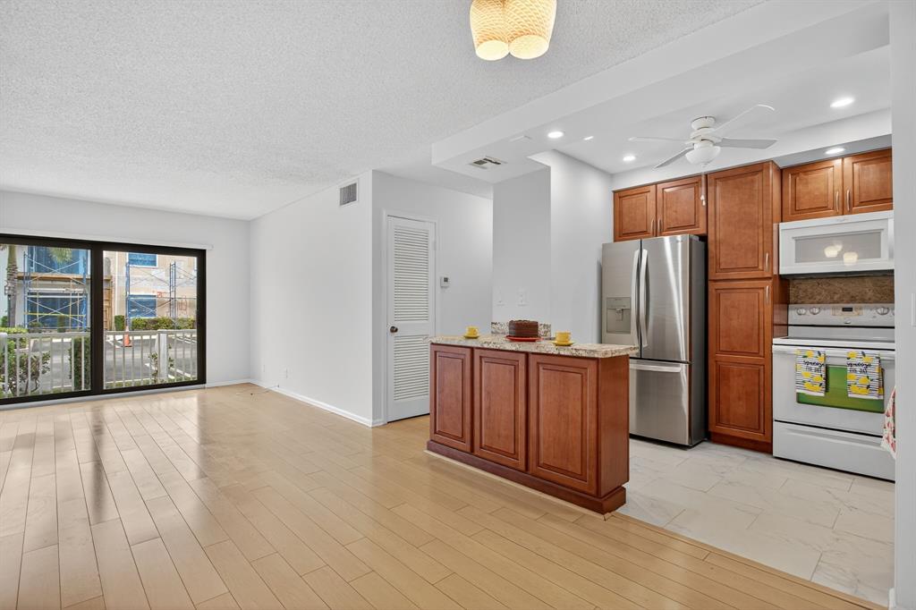 130 Cypress Club Drive, Unit 307 Pompano Beach, FL 33060 - Photo 7 of 35 a kitchen with stainless steel appliances granite countertop a refrigerator a sink and a stove